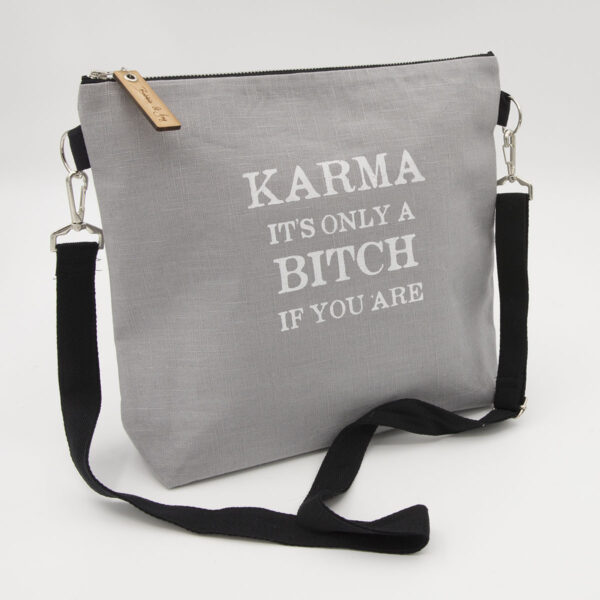 Silver linen zipped bag with karma. It's only a bitch if you are print
