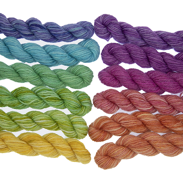 Set of twelve semi solid colours of Britsock mini skeins making up a colour wheel of 12 printer ink hues displayed in two lines