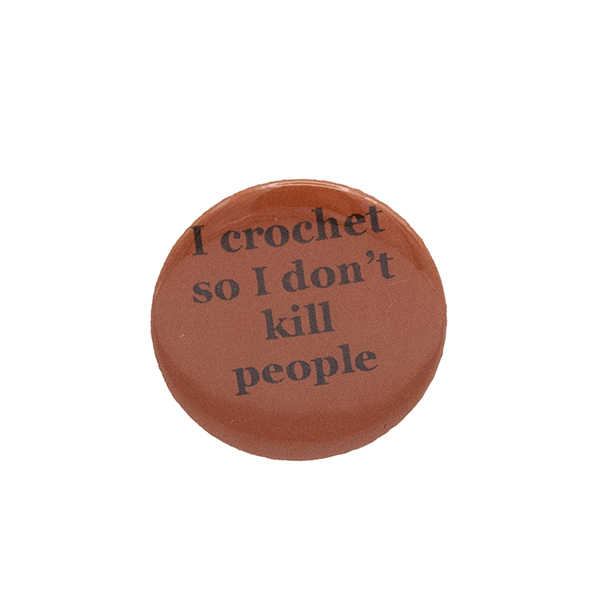 Orange button badge with black writing which reads I crochet so I don't kill people
