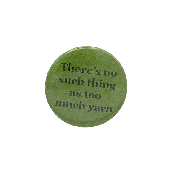 Green button badge with black writing which reads There's no such thing as too much yarn