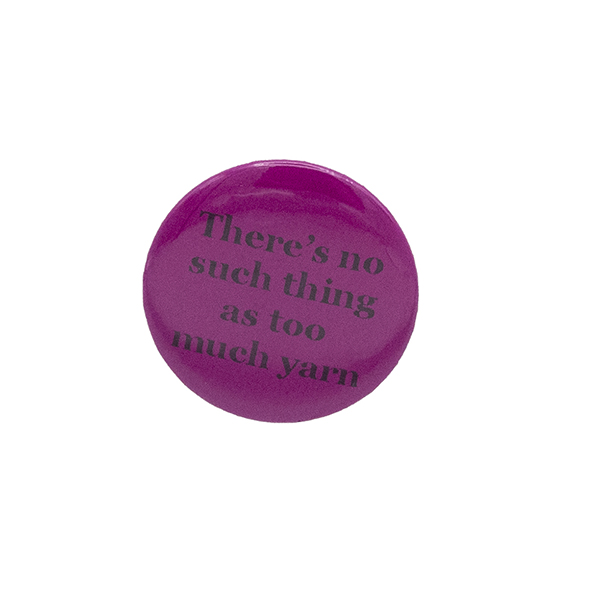 Pink button badge with black writing which reads There's no such thing as too much yarn