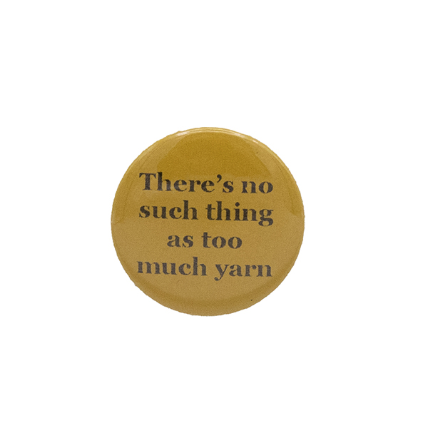 Yellow button badge with black writing which reads There's no such thing as too much yarn