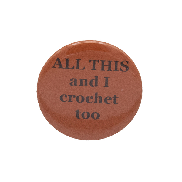 Orange button badge with black writing which reads ALL THIS and I crochet too