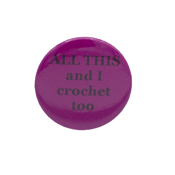 Pink button badge with black writing which reads ALL THIS and I crochet too