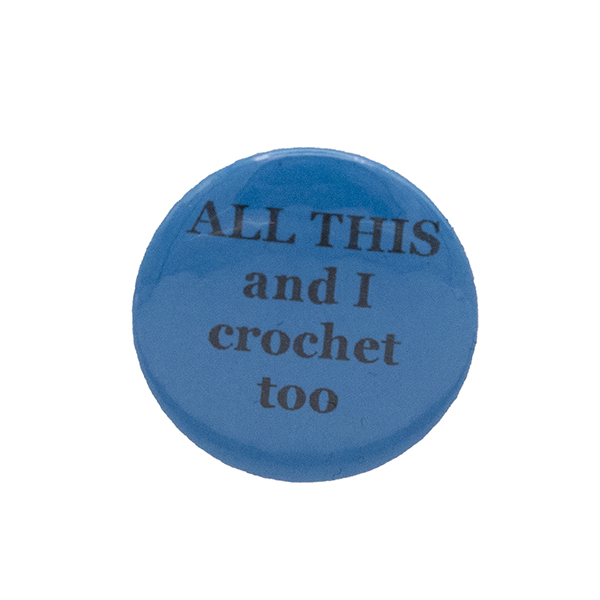 Turquoise button badge with black writing which reads ALL THIS and I crochet too