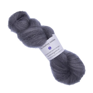 skein of hand dyed fluffy yarn in baby elephant with The Knitting Goddess label