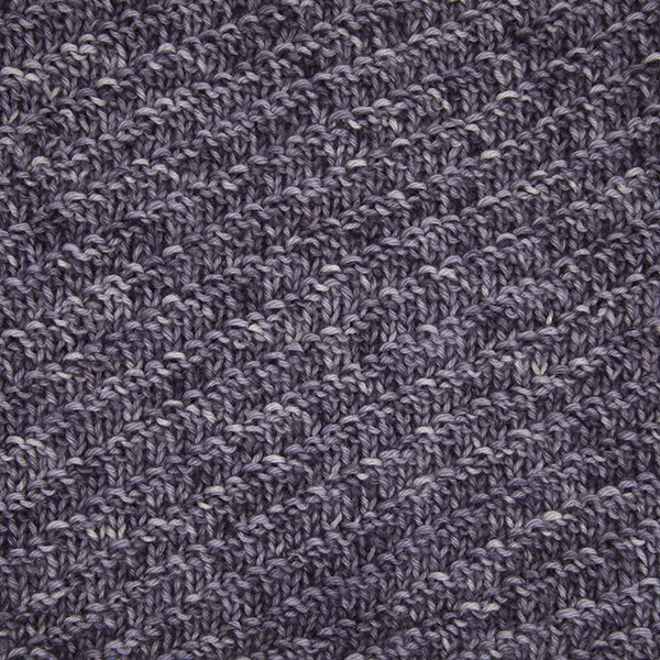 close up of grey knitted pattern with diagonal bands of reverse stocking stitch