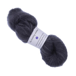 skein of hand dyed fluffy yarn in coal with The Knitting Goddess label