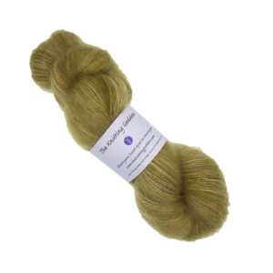 skein of hand dyed fluffy yarn in gold with The Knitting Goddess label