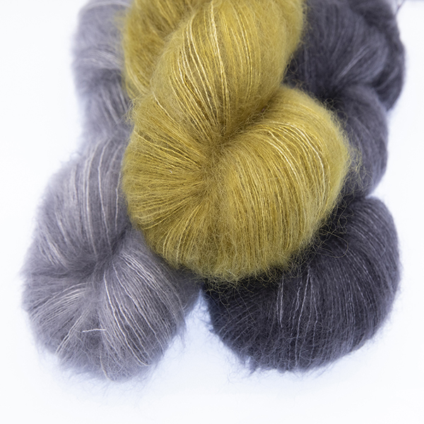 three skeins of fluffy hand dyed Moonbroch yarn in silver, charcoal and gold