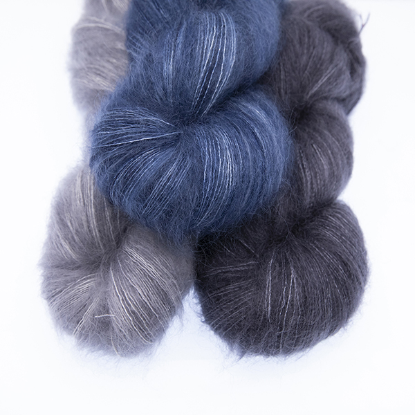 three skeins of fluffy hand dyed Moonbroch yarn in silver, charcoal and navy