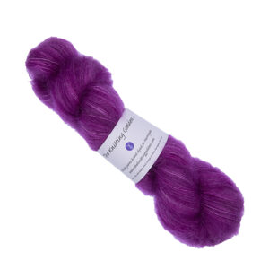 skein of hand dyed fluffy yarn in raspberry with The Knitting Goddess label