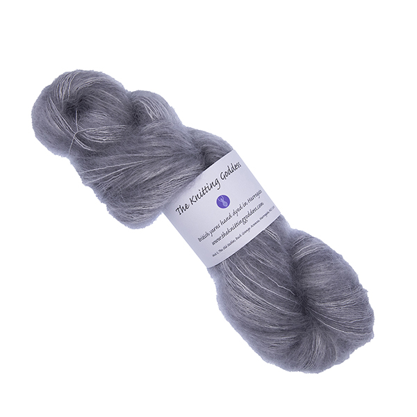 skein of hand dyed fluffy yarn in silver with The Knitting Goddess label