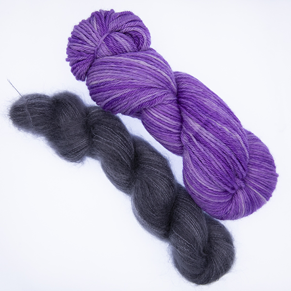 skein of double knit purple yarn and smaller skein of dark grey fluffy yarn