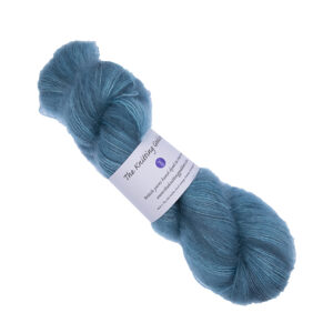 skein of hand dyed fluffy yarn in turquoise with The Knitting Goddess label