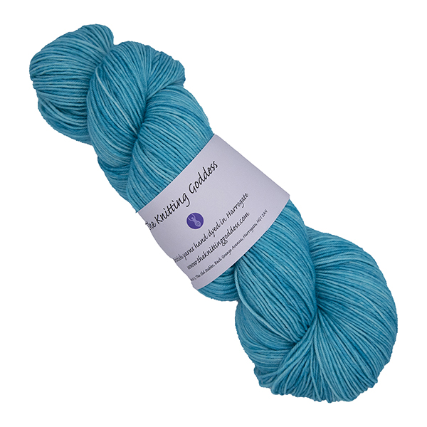 skein of hand dyed turquoise yarn with The Knitting Goddess label