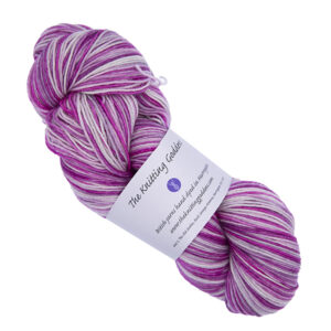 skein of hand dyed yarn in frosted berry colourway bright raspberry pink, paler pink and white with a hint of pink with The Knitting Goddess ball band