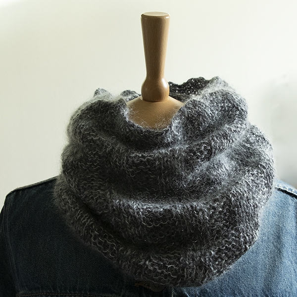 Knitted cowl with a ribbed texture knitted in charcoal grey and pale blue, displayed on a mannequin