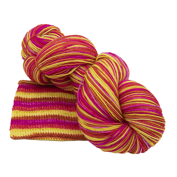 skein of burn it up self striping yarn with pink, red, copper and gold hand dyed by The Knitting Goddess
