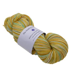 skein of yarn with gold, sand, turquoise and silver with The Knitting Goddess ball band
