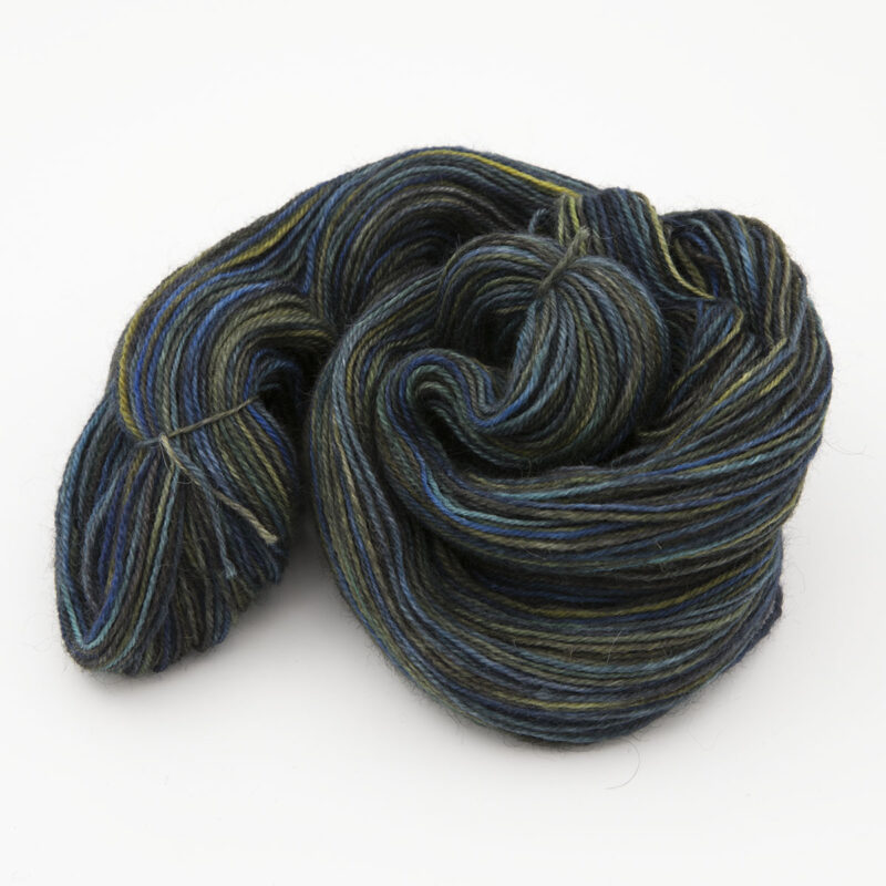 skein of hand dyed yarn, mainly dark with spots of blue and turquoise