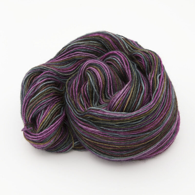 skein of hand dyed yarn, mainly dark dyed over gold, raspberry and turquoise
