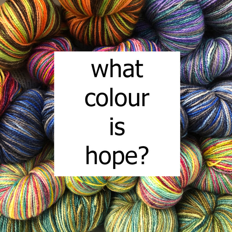 words "what colour is hope" on top of a bundle of multi coloured yarn