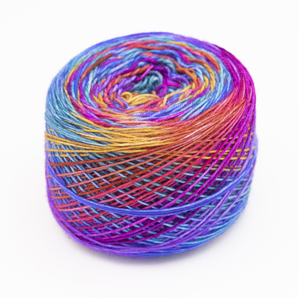 Ball of purple rainbow self striping sock yarn. Yarn is dyed in the 8 colours of the pride rainbow flag, then overdyed with purple.