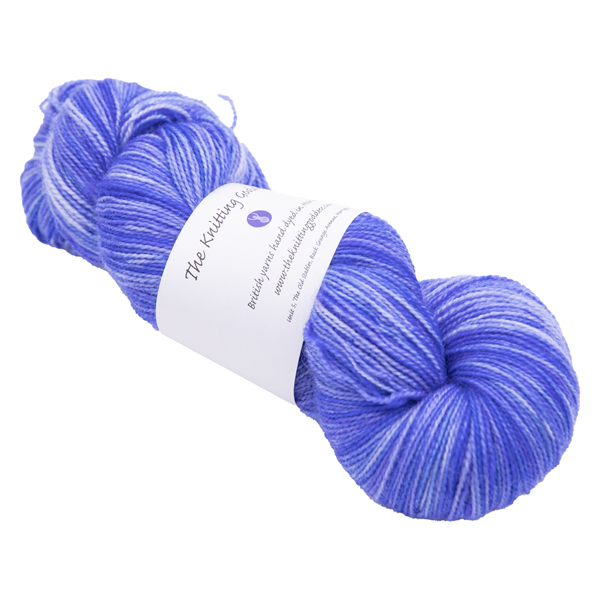 skein of hand dyed cornflower blue sock yarn with The Knitting Goddess ball band