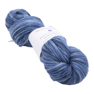 skein of hand dyed navy blue sock yarn with The Knitting Goddess ball band