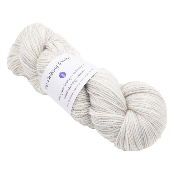 skein of hand dyed pale silver sock yarn with The Knitting Goddess ball band