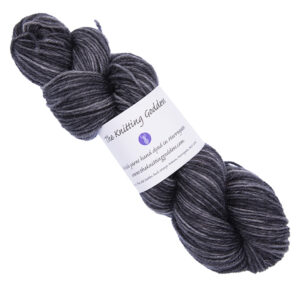 charcoal grey skein of hand dyed yarn with The Knitting Goddess ball band