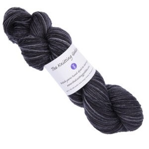 dark grey skein of hand dyed yarn with The Knitting Goddess ball band