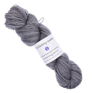 soft grey skein of hand dyed yarn with The Knitting Goddess ball band