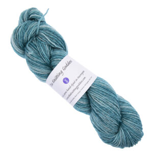 jade green skein of hand dyed yarn with The Knitting Goddess ball band