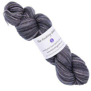 gunmetal grey skein of hand dyed yarn with The Knitting Goddess ball band