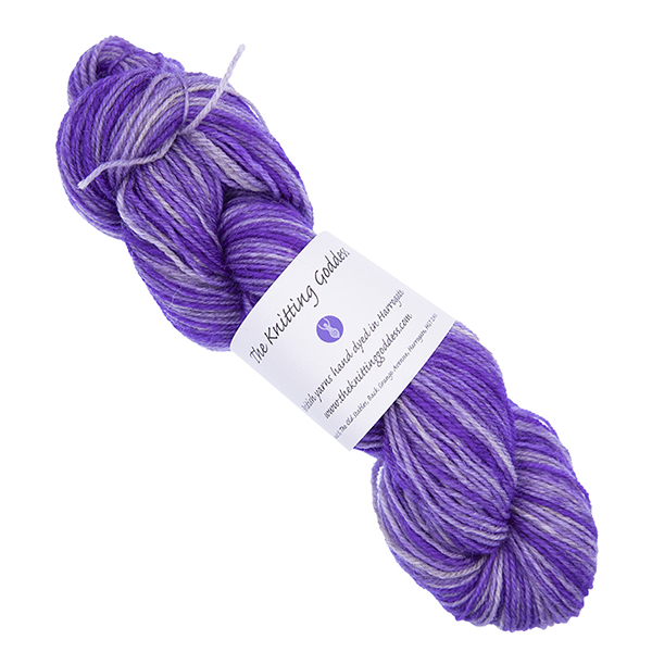 purple skein of hand dyed yarn with The Knitting Goddess ball band