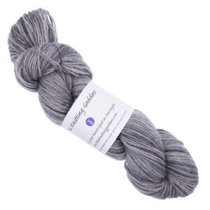 silver skein of hand dyed yarn with The Knitting Goddess ball band
