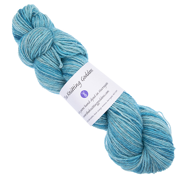 turquoise skein of hand dyed yarn with The Knitting Goddess ball band
