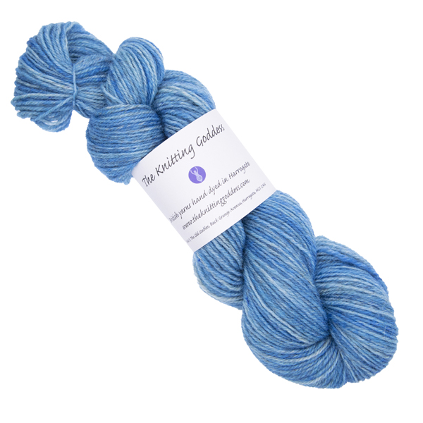 blue skein of hand dyed yarn with The Knitting Goddess ball band