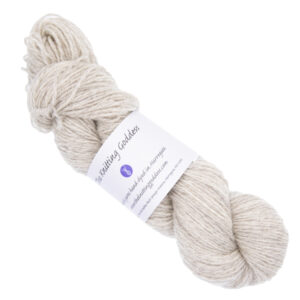 pale silver skein of hand dyed yarn with The Knitting Goddess ball band