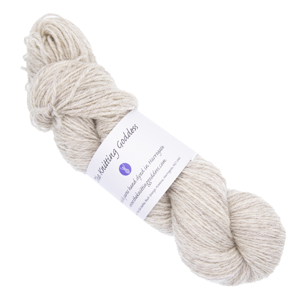 pale silver skein of hand dyed yarn with The Knitting Goddess ball band