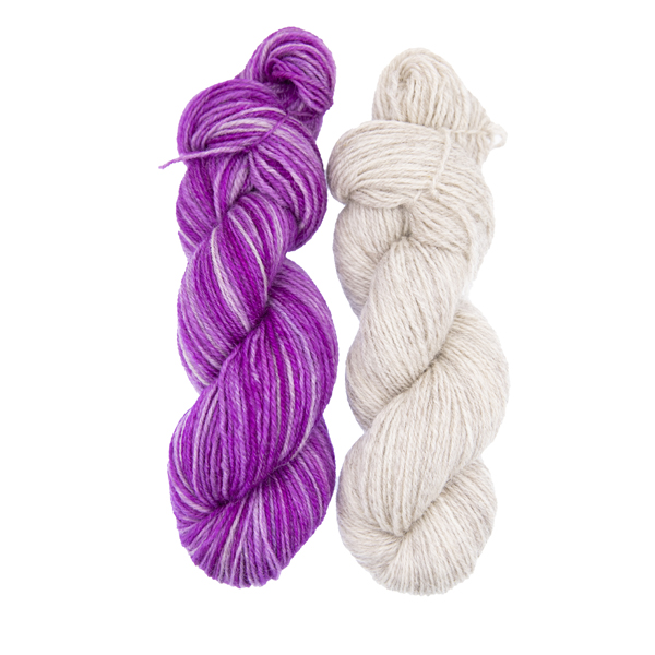 two skeins of hand dyed yarn, one pinkish purple, the other pale silver