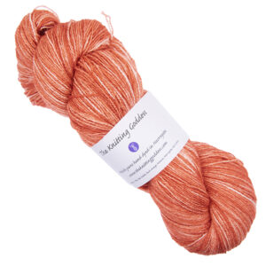 copper orange skein of hand dyed wool and silk yarn with The Knitting Goddess ball band