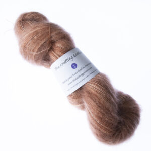 Caramel hand dyed fluffy mohair silk yarn in a skein with The Knitting Goddess ball band