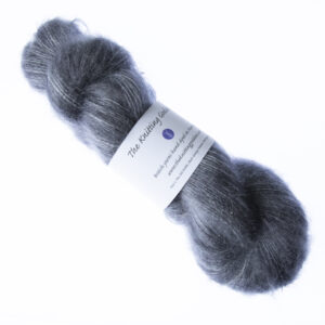 Charcoal hand dyed fluffy mohair silk yarn in a skein with The Knitting Goddess ball band