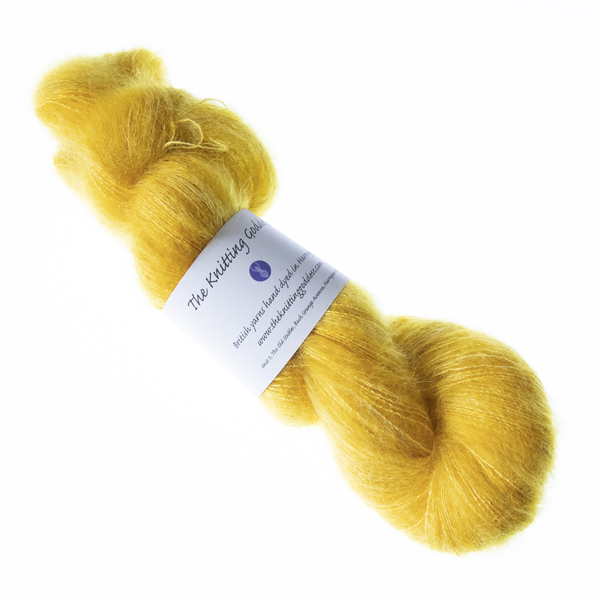 Gold hand dyed fluffy mohair silk yarn in a skein with The Knitting Goddess ball band