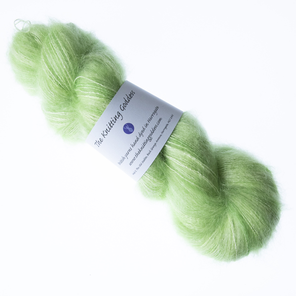 Lime hand dyed fluffy mohair silk yarn in a skein with The Knitting Goddess ball band
