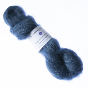 Navy hand dyed fluffy mohair silk yarn in a skein with The Knitting Goddess ball band