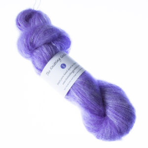 Purple hand dyed fluffy mohair silk yarn in a skein with The Knitting Goddess ball band
